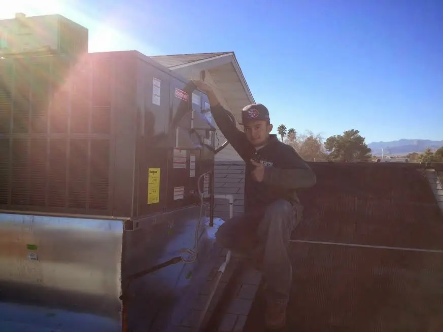 HVAC technician performing Heat Pump Repair on a rooftop unit in Edmond